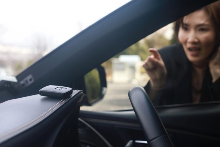 Woman reacting with frustration outside a car window where keys are left on the dashboard.